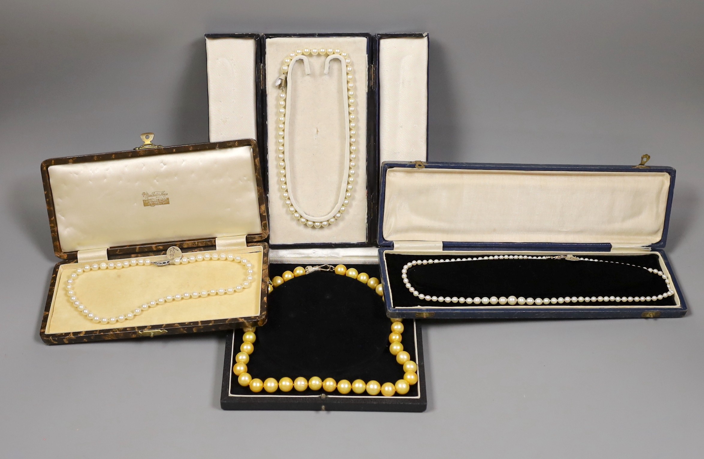 Four assorted cased single strand cultured pearl necklaces, with yellow metal or sterling clasps, longest 48cm.